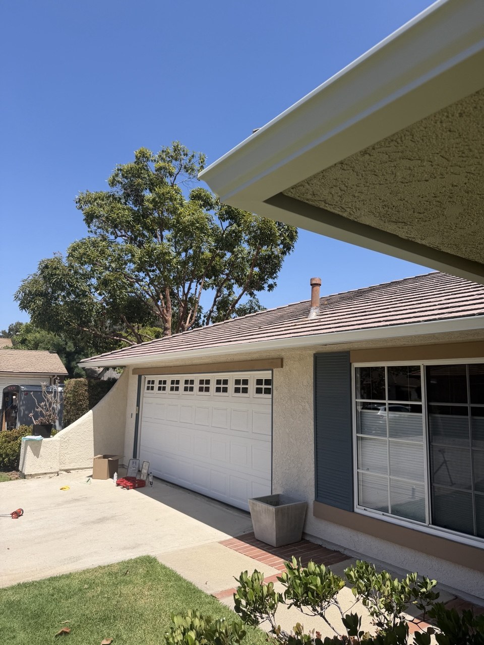 New white seamless gutter installation on California tile roof home - Flashpoint Builders